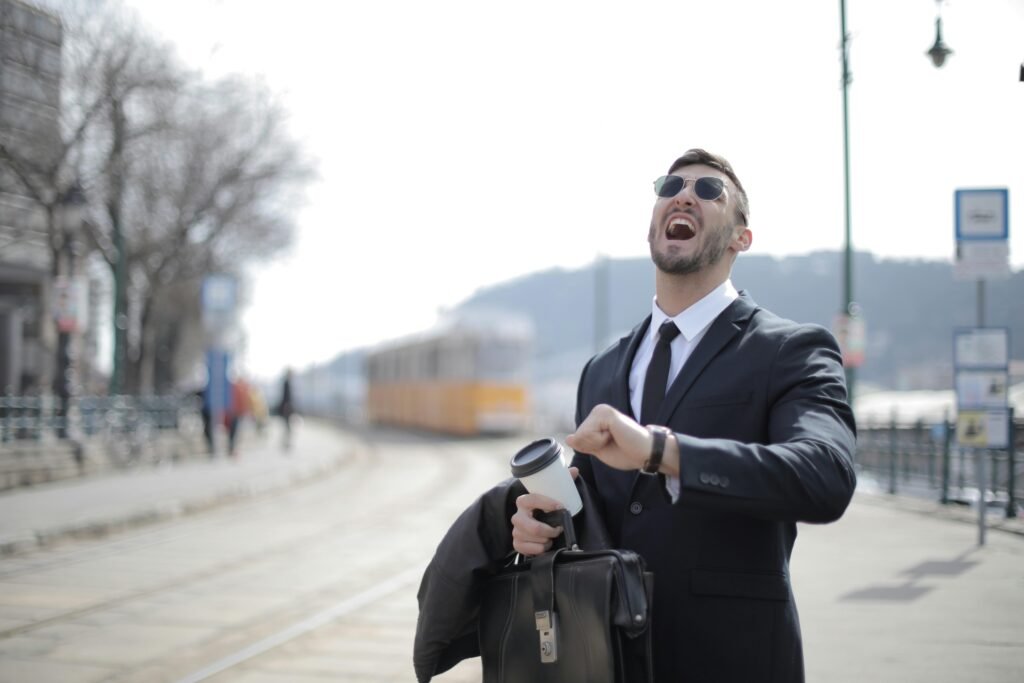 pexels-photo-3778585-3778585 Businessman in sunglasses laughing while holding a coffee cup outdoors. Captures energy and expression.